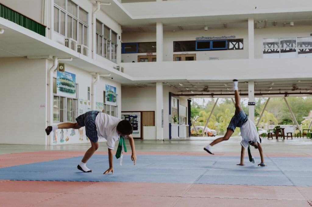 boys in school uniforms performing cartwheels in school gymnasium